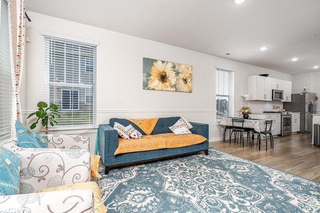 living area featuring recessed lighting, wood finished floors, and baseboards