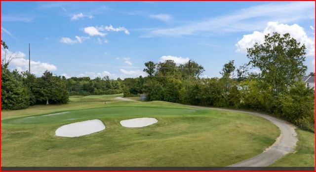view of home's community with view of golf course and a lawn