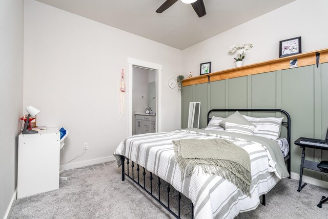 carpeted bedroom with baseboards, ceiling fan, and ensuite bathroom