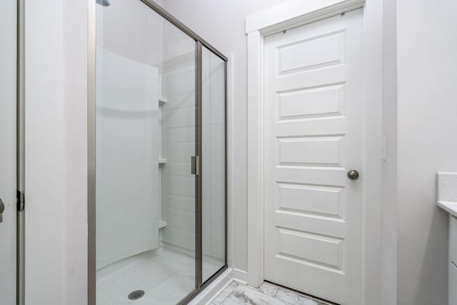 full bath featuring marble finish floor and a stall shower