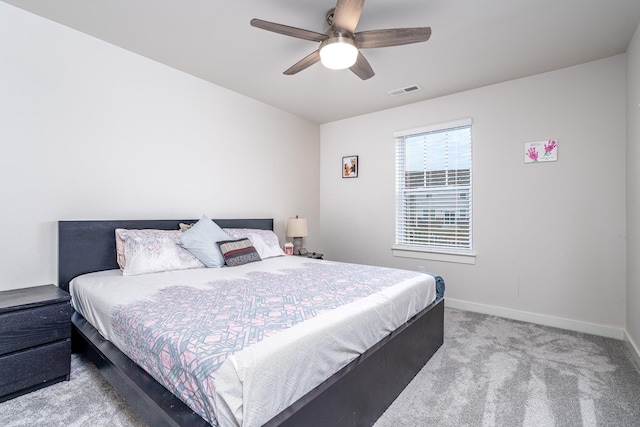 carpeted bedroom with baseboards, a ceiling fan, and visible vents