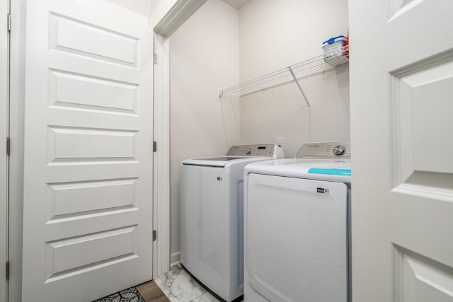 laundry area with light wood finished floors, washer and dryer, and laundry area