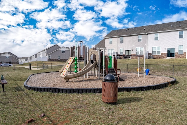 communal playground with fence, a lawn, and a residential view