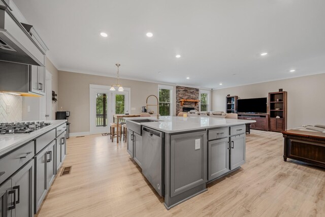 3032 Oxford Dr, Mount Juliet, TN 37122 - kitchen with stainless steel appliances, a sink, tasteful backsplash, light wood-style floors, and gray cabinetry