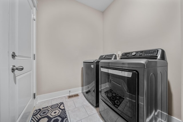 3032 Oxford Dr, Mount Juliet, TN 37122 - laundry area featuring washing machine and clothes dryer, light tile patterned flooring, baseboards, visible vents, and laundry area