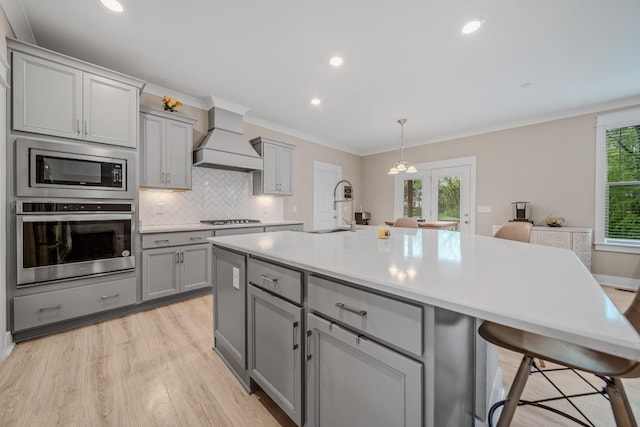 3032 Oxford Dr, Mount Juliet, TN 37122 - kitchen with stainless steel appliances, light wood-style flooring, a sink, custom exhaust hood, and gray cabinetry