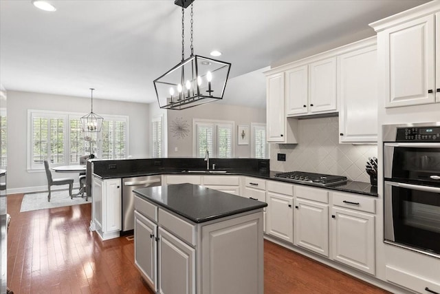 9502 Peebles Ct, Brentwood, TN 37027 - kitchen featuring stainless steel appliances, a peninsula, a sink, a healthy amount of sunlight, and an inviting chandelier