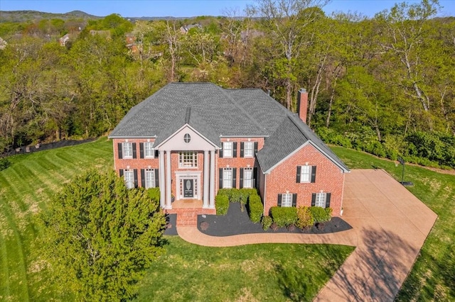 9502 Peebles Ct, Brentwood, TN 37027 - view of front of house featuring a front lawn, a chimney, brick siding, and a view of trees