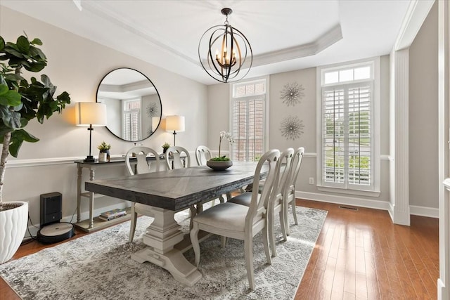 9502 Peebles Ct, Brentwood, TN 37027 - dining room with a tray ceiling, baseboards, hardwood / wood-style flooring, and an inviting chandelier