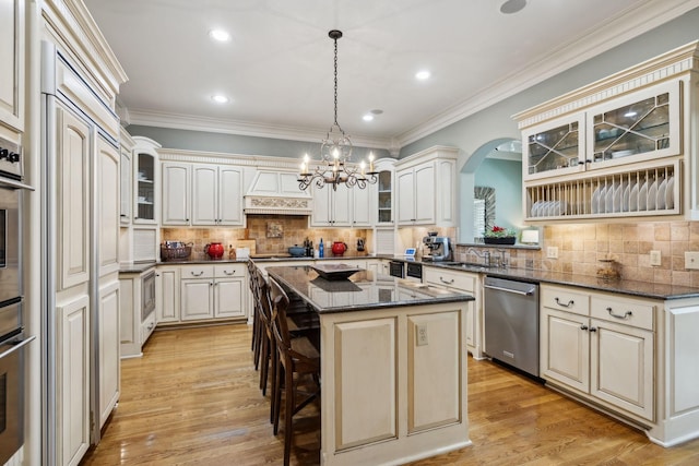 kitchen featuring a kitchen breakfast bar, tasteful backsplash, dishwasher, a kitchen island, and ornamental molding