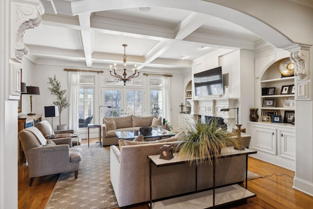 living area featuring arched walkways, coffered ceiling, beamed ceiling, wood finished floors, and crown molding