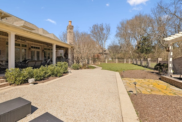 view of yard with fence, a ceiling fan, and a patio