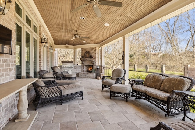 view of patio / terrace featuring grilling area, fence, an outdoor living space with a fireplace, and ceiling fan