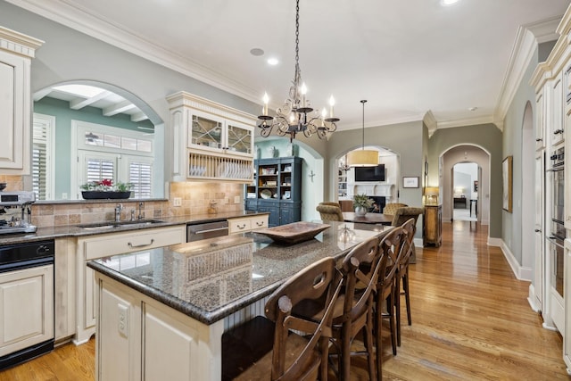 kitchen with a kitchen bar, arched walkways, backsplash, and a kitchen island