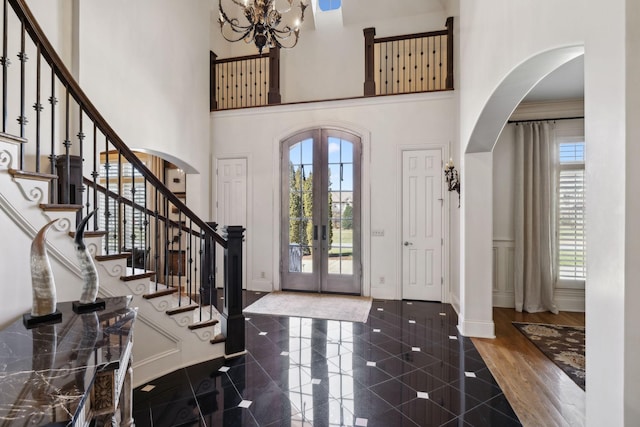 entryway featuring a high ceiling, granite finish floor, french doors, and arched walkways
