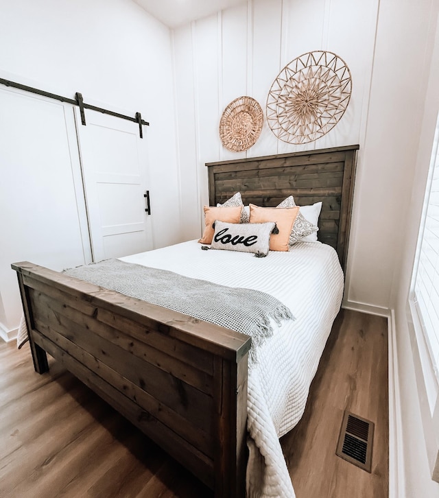 135 Hemlock Cv, Tracy City, TN 37387 - bedroom featuring visible vents, a barn door, baseboards, and wood finished floors