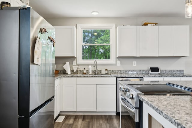 kitchen with white cabinets, stainless steel appliances, a sink, and dark wood finished floors