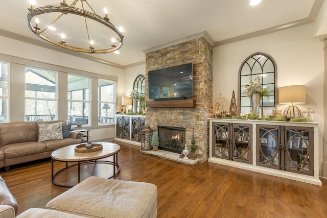 living area with an inviting chandelier, wood finished floors, crown molding, baseboards, and a fireplace
