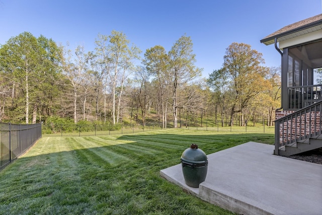 view of yard with a sunroom, stairway, a fenced backyard, and a patio area