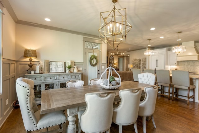 dining space featuring recessed lighting, a decorative wall, a chandelier, wainscoting, and dark wood-style flooring