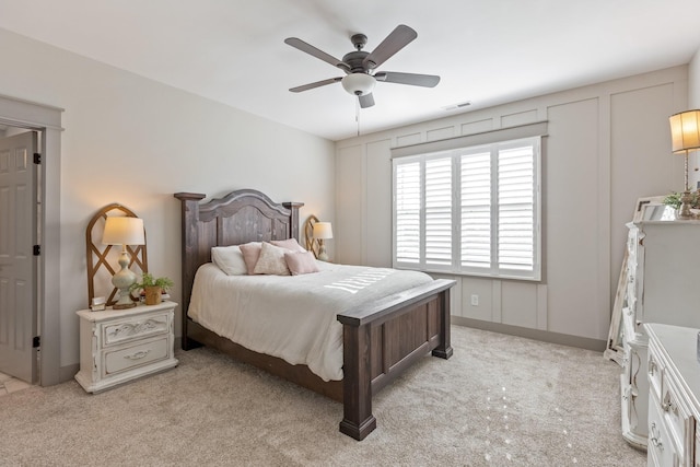 bedroom featuring visible vents, a ceiling fan, and light carpet