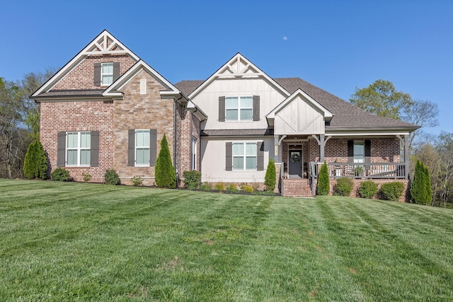 craftsman house with board and batten siding, a front lawn, covered porch, and brick siding