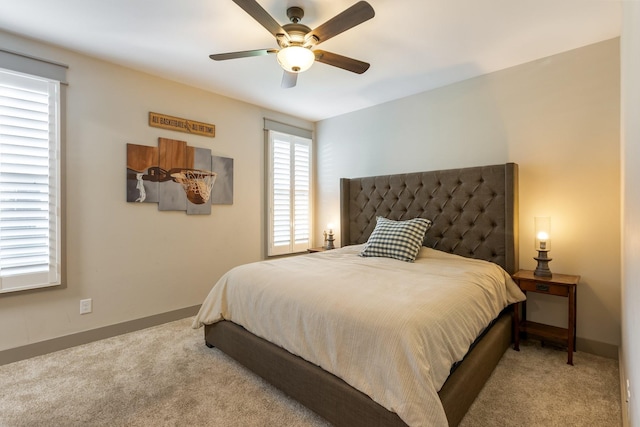 carpeted bedroom with ceiling fan and baseboards
