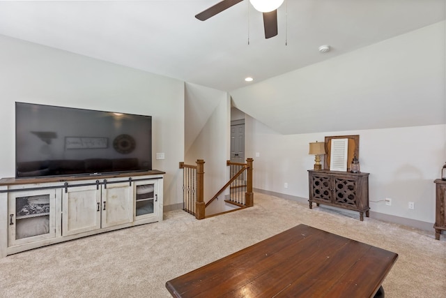living area featuring ceiling fan, lofted ceiling, baseboards, and carpet