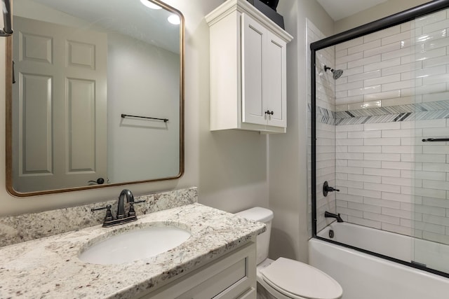 bathroom with enclosed tub / shower combo, toilet, and vanity