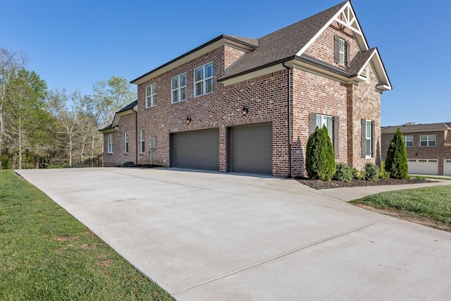 view of side of home featuring driveway, roof with shingles, brick siding, and a garage