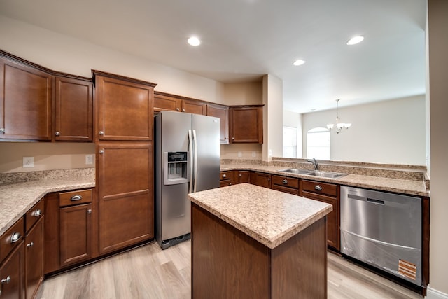 kitchen with light wood-style flooring, a chandelier, stainless steel appliances, and a sink