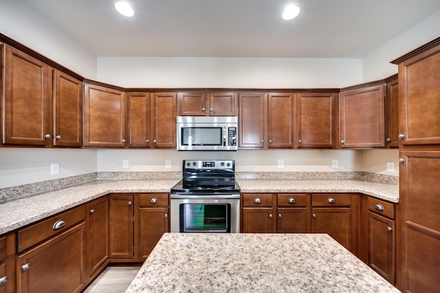 kitchen featuring light stone countertops, stainless steel appliances, and recessed lighting