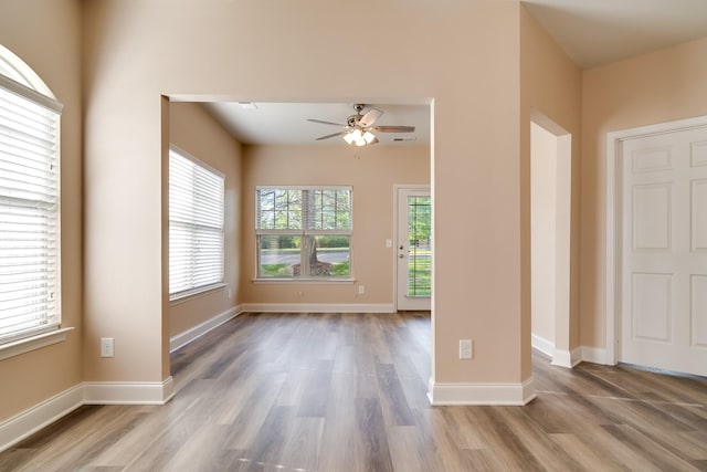 unfurnished room featuring wood finished floors, baseboards, and ceiling fan