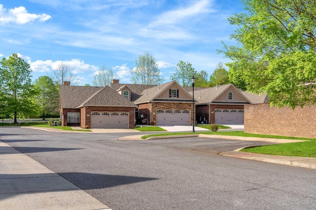 multi unit property with brick siding, an attached garage, and a chimney