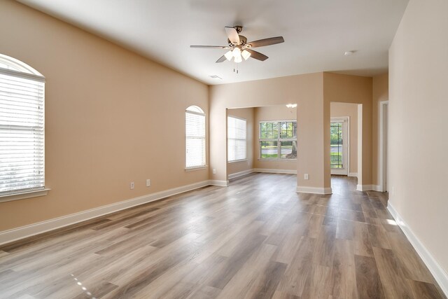empty room featuring baseboards, a ceiling fan, and wood finished floors