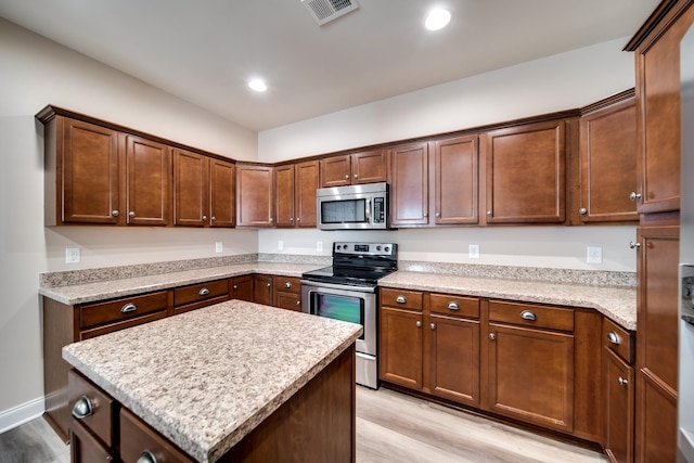 kitchen with stainless steel appliances, visible vents, recessed lighting, light wood-style floors, and a kitchen island