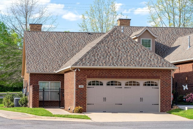 view of front of property with brick siding, a shingled roof, a chimney, and a garage