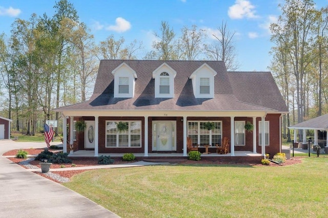 view of front of home featuring fence, a front lawn, and covered porch