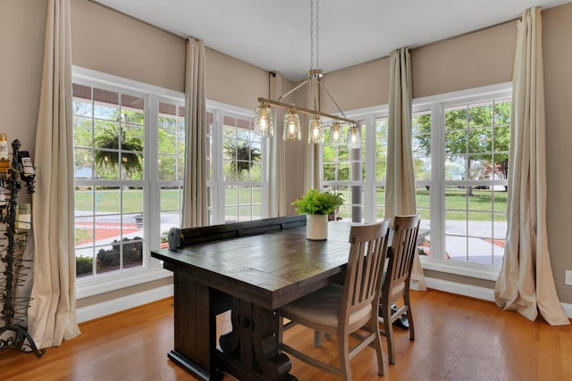 dining space with baseboards and light wood-type flooring