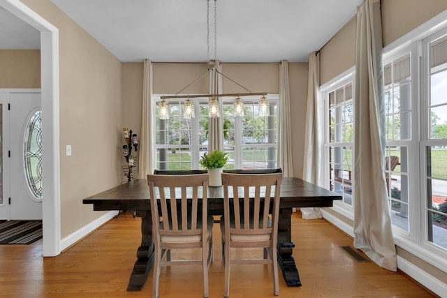 dining area featuring a notable chandelier, visible vents, baseboards, and a healthy amount of sunlight