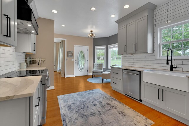 kitchen featuring tasteful backsplash, stainless steel appliances, plenty of natural light, and a sink