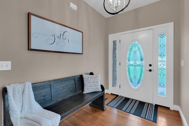 entrance foyer featuring a chandelier, baseboards, and wood finished floors