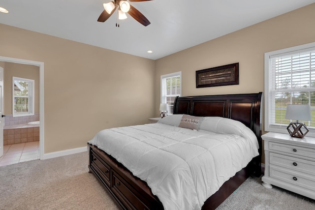 bedroom featuring ensuite bath, recessed lighting, baseboards, and light carpet