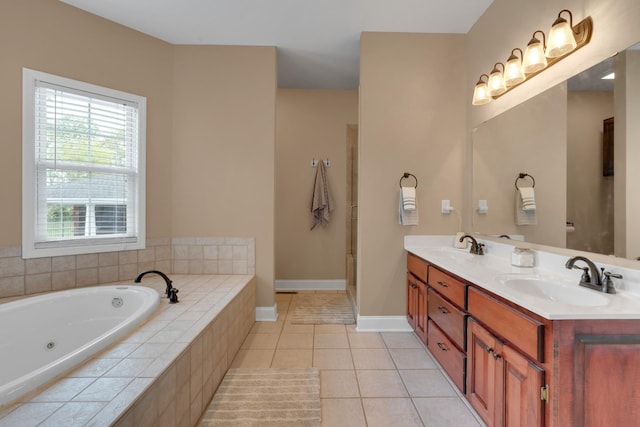 full bath with a jetted tub, a sink, double vanity, and tile patterned floors