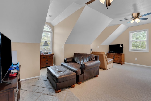 living area with lofted ceiling, ceiling fan, a healthy amount of sunlight, and baseboards