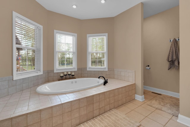full bathroom featuring a bath, tile patterned flooring, and baseboards