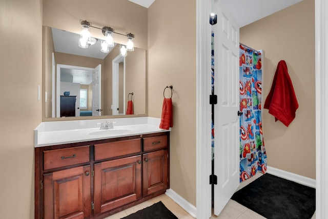 full bath with curtained shower, tile patterned flooring, vanity, and baseboards