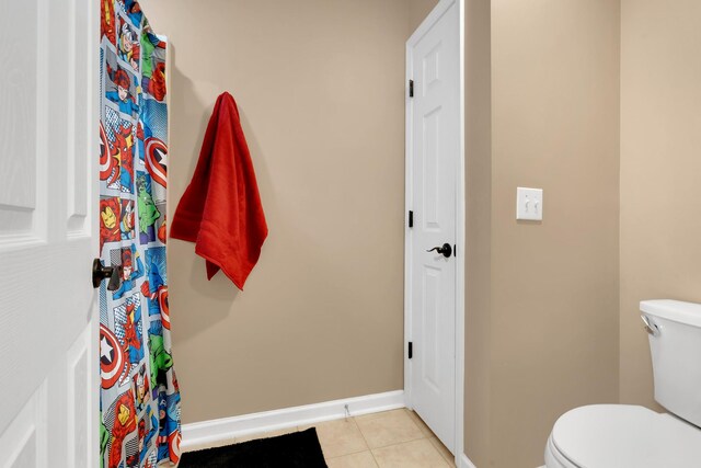 bathroom with toilet, tile patterned floors, and baseboards