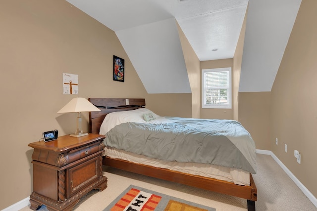 carpeted bedroom featuring baseboards and vaulted ceiling