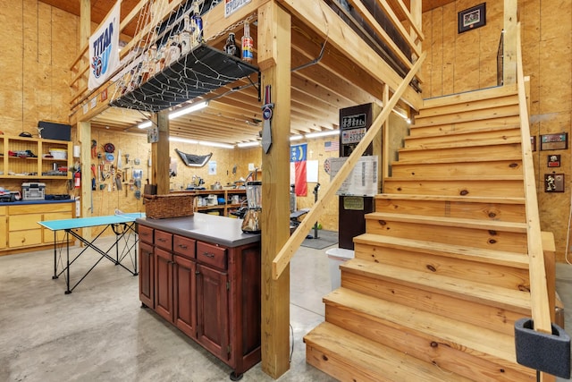 stairway featuring a workshop area and concrete flooring
